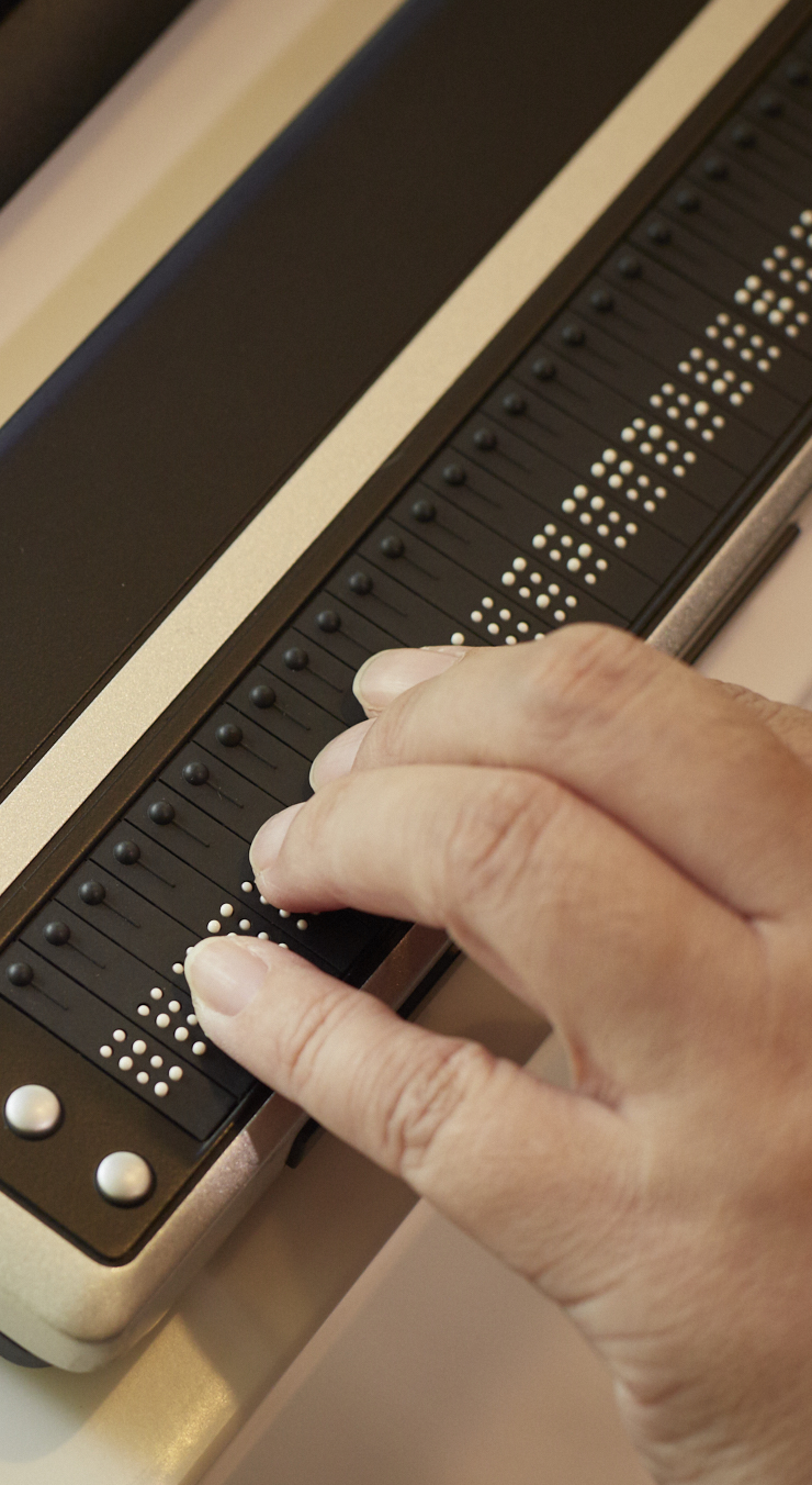 A hand touches the Brailliant 80, a Braille refreshable display.