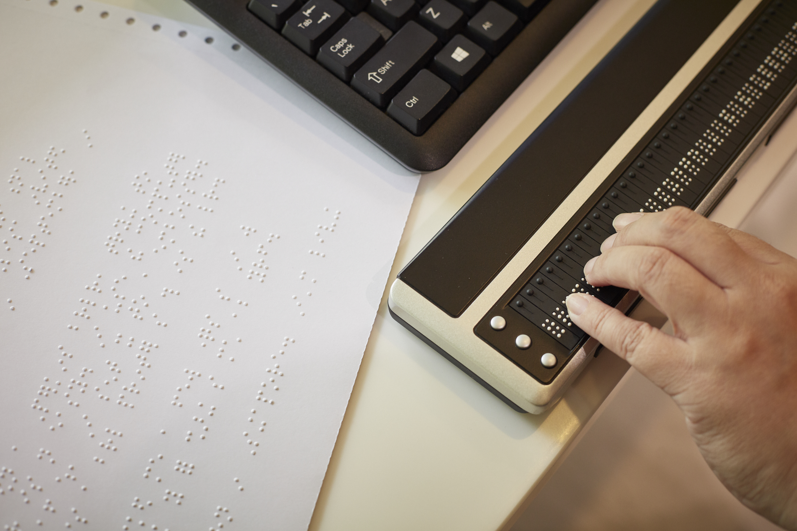 A hand touches the Brailliant 80, a Braille refreshable display.