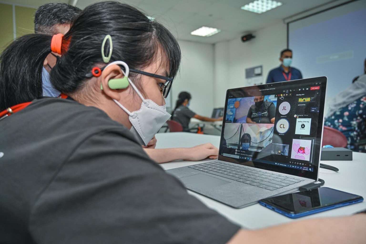 A girl wearing a hearing aid is on a Zoom meeting as part of the Digital Enablement Programme.