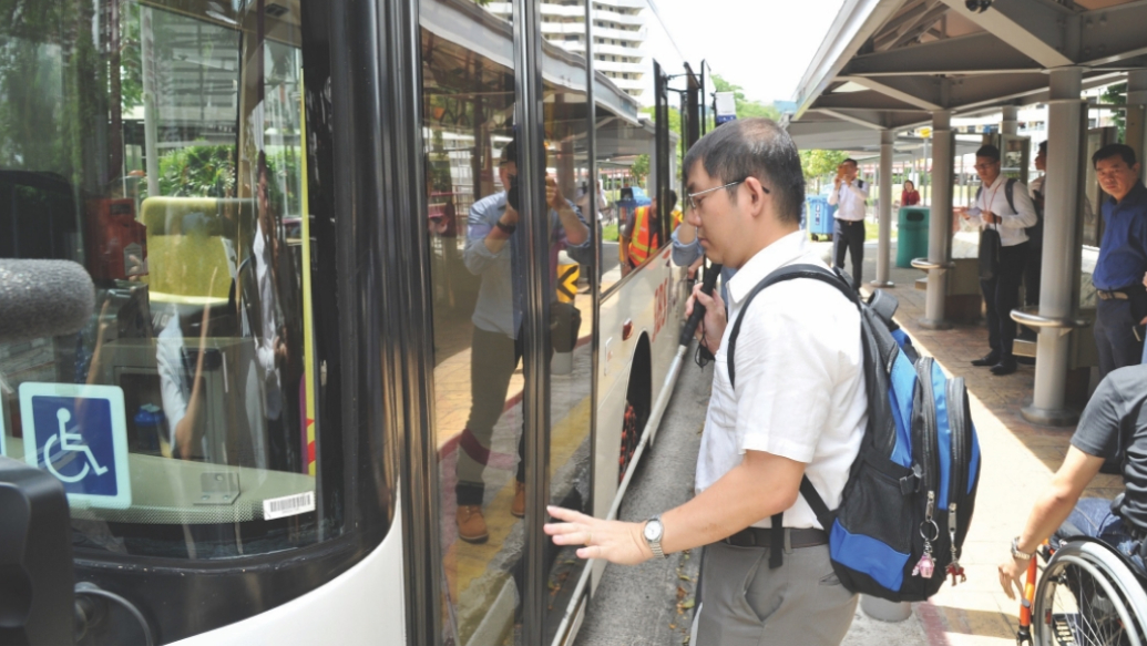 A person with visual impairment boarding the bus with the use of MAVIS.