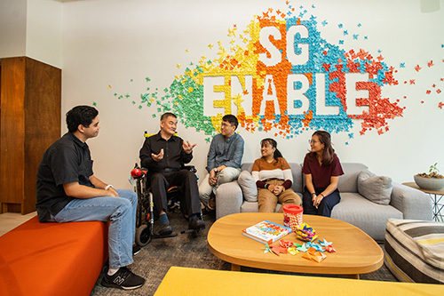 A group of people gathered around a couch, having a discussion