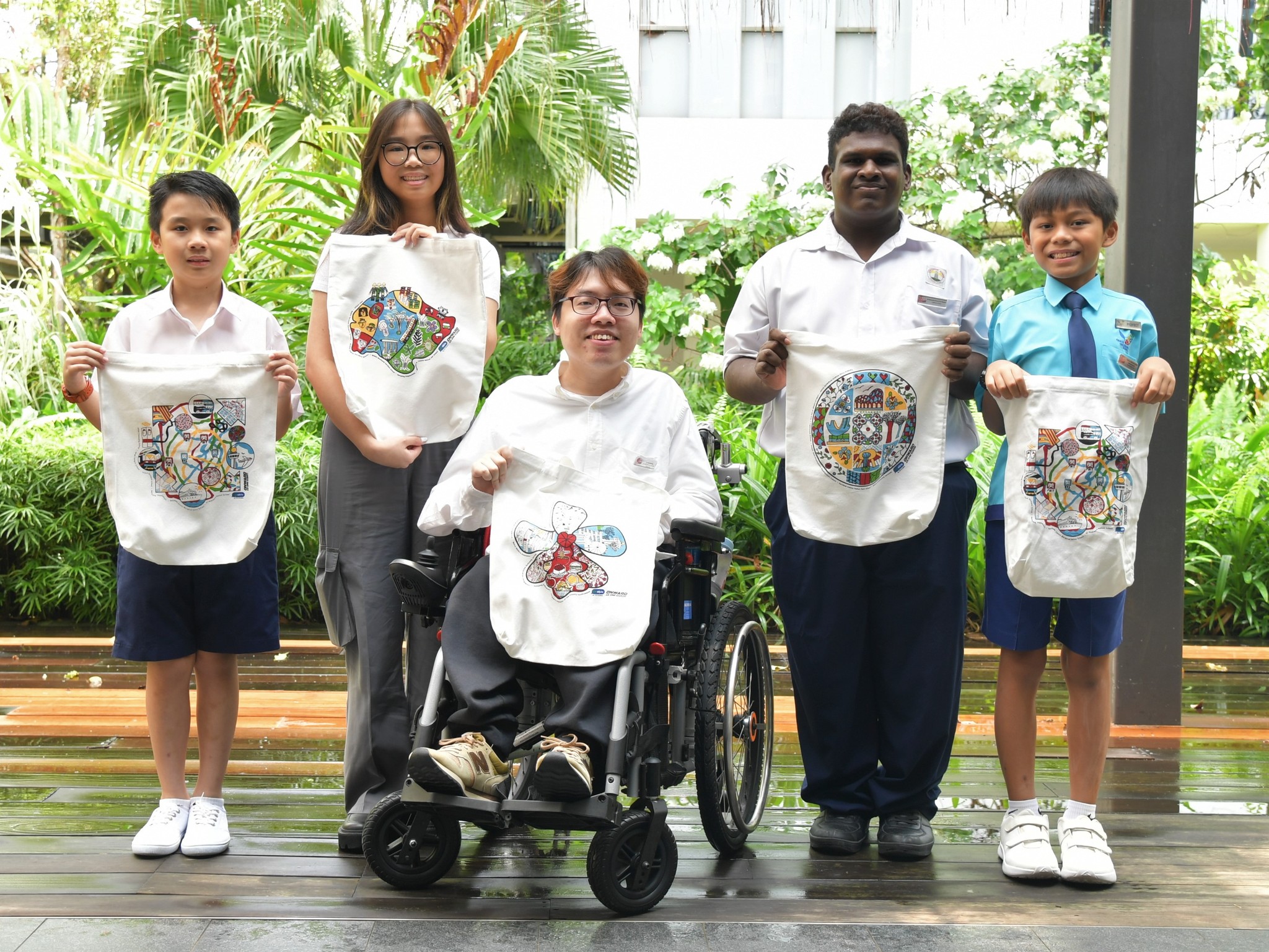 A group photo of 5 artists holding up NDP 2023 tote bags.