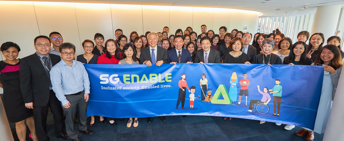 SG Enable's staff and Deputy Prime Minister Lawrence Wong with an SG Enable banner at the Inclusive Business Forum 2022.