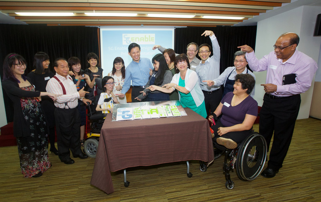 Group photo from the official launch of SG Enable, featuring then Minister of Social and Family Development, Mr Chan Chun Sing. The group is around a table with the logo SG Enable pieced across it.