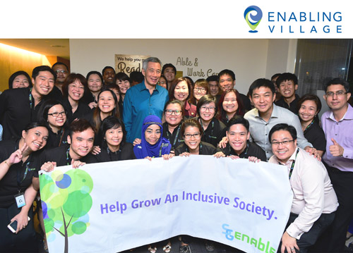 Group photo of Prime Minister Lee Hsien Loong, then Minister of Social and Family Development Mr Tan Chuan Jin, and SG Enable staff at the opening of Enabling Village.