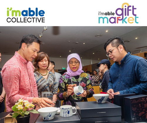 President Halimah Yacob admiring a cup being sold at the i'mable Gift Market.