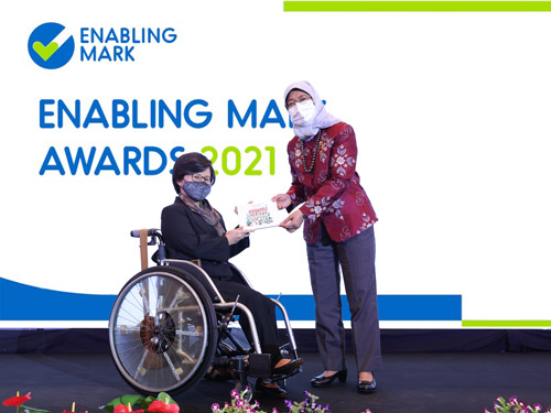 First Enabling Mark Awards Ceremony - Cover President Halimah presenting a wheelchair user with an award at the Enabling Mark Awards 2021.