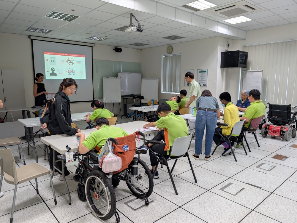 A group of persons with disabilities undergoing training in a classroom.