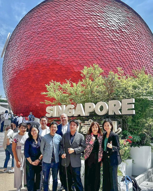 A group of SG Enable staff and partners in front of the SG Pavilion at Expo 2025 in Osaka.