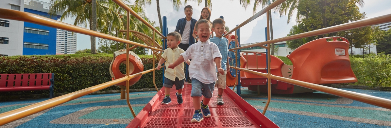 A family with three young children enjoying their time at the playground in Enabling Village