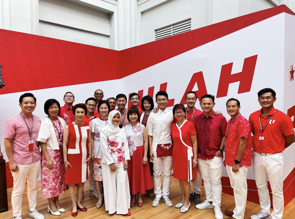 A group photo of members of the Parliament, some of them are wearing outfits from the Motif Majulah collection.