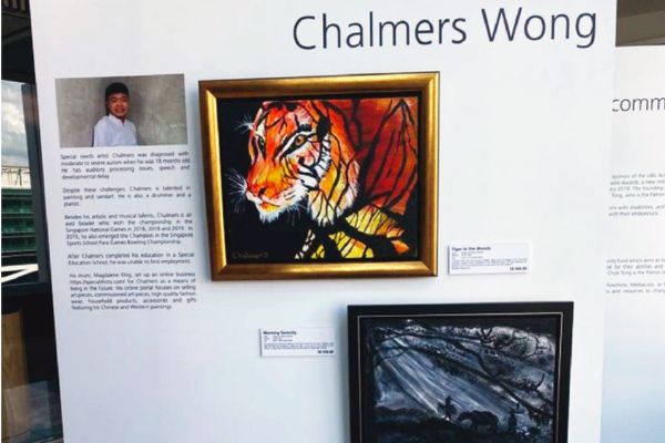 Paintings on a wall, with the artist's name, 'Chalmers Wong'