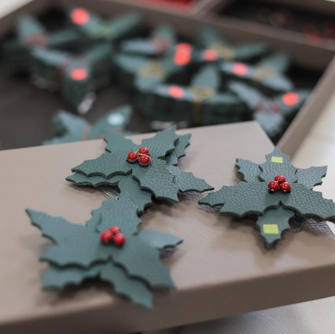 Christmas-themed hand-crafted leather brooches on display