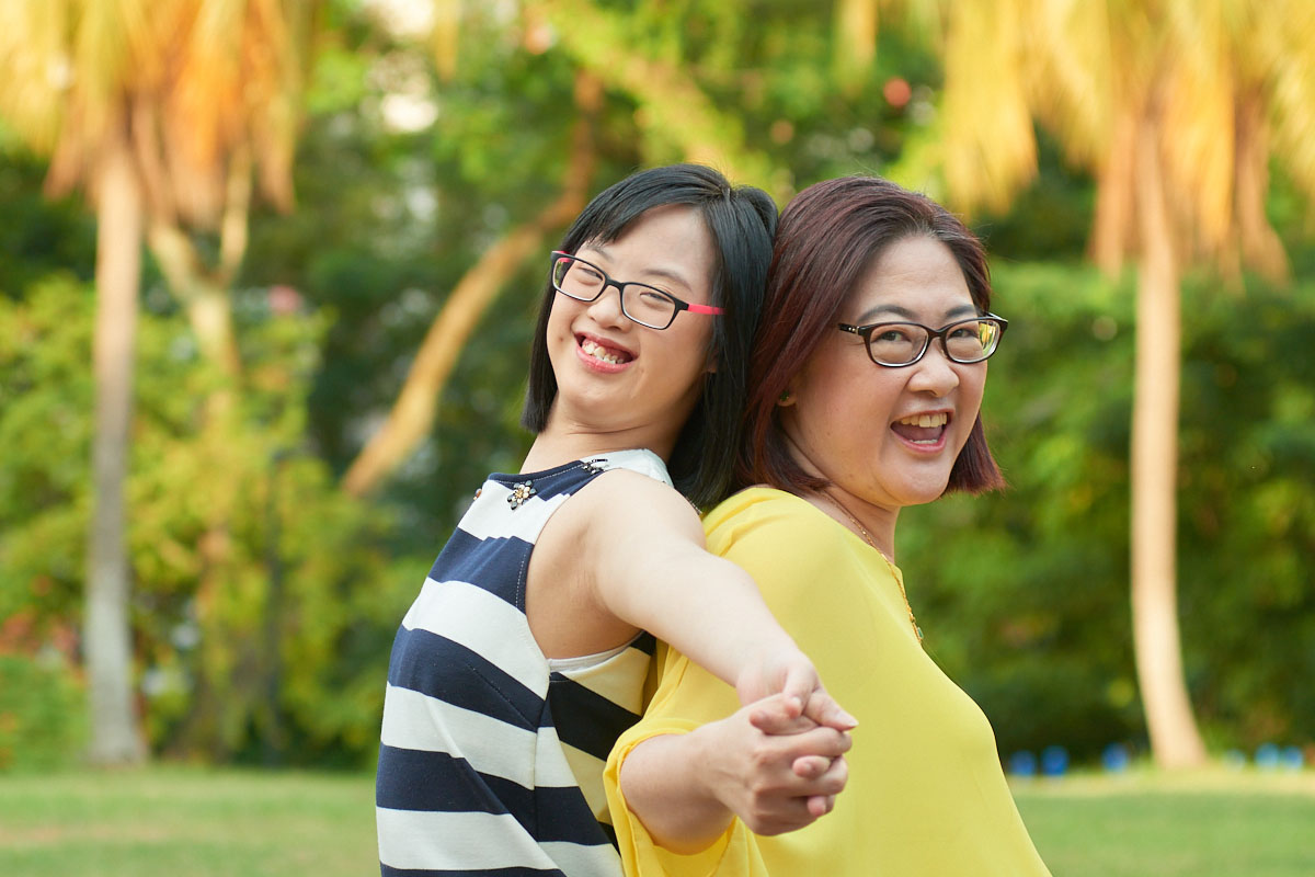 A mother and child who has down syndrome poses for a photo.