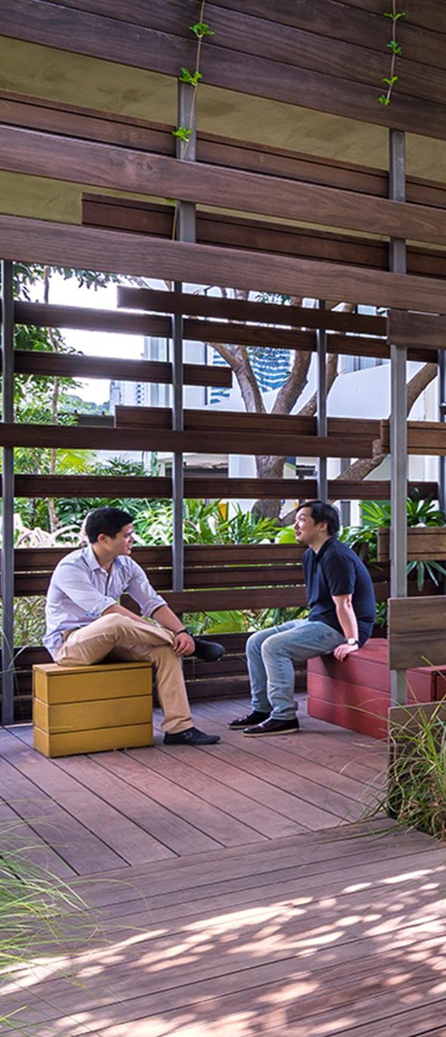 Two men chatting with each other in a cabana in the Enabling Village