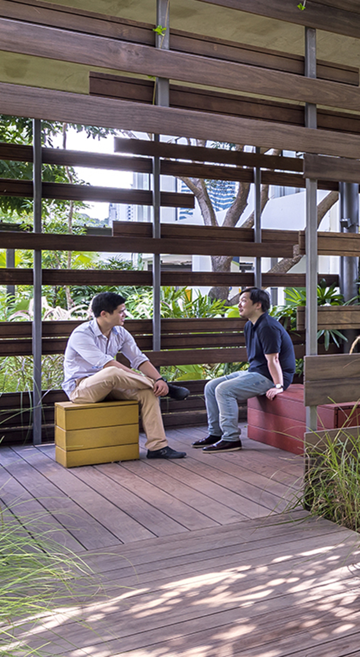 Two men chatting with each other in a cabana in the Enabling Village