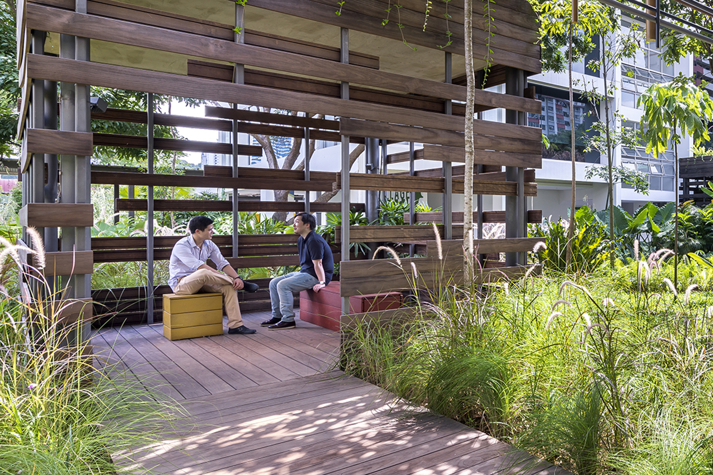 Two men chatting with each other in a cabana in the Enabling Village