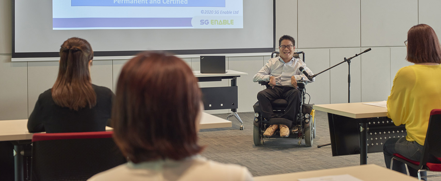 A wheelchair user giving a presentation.