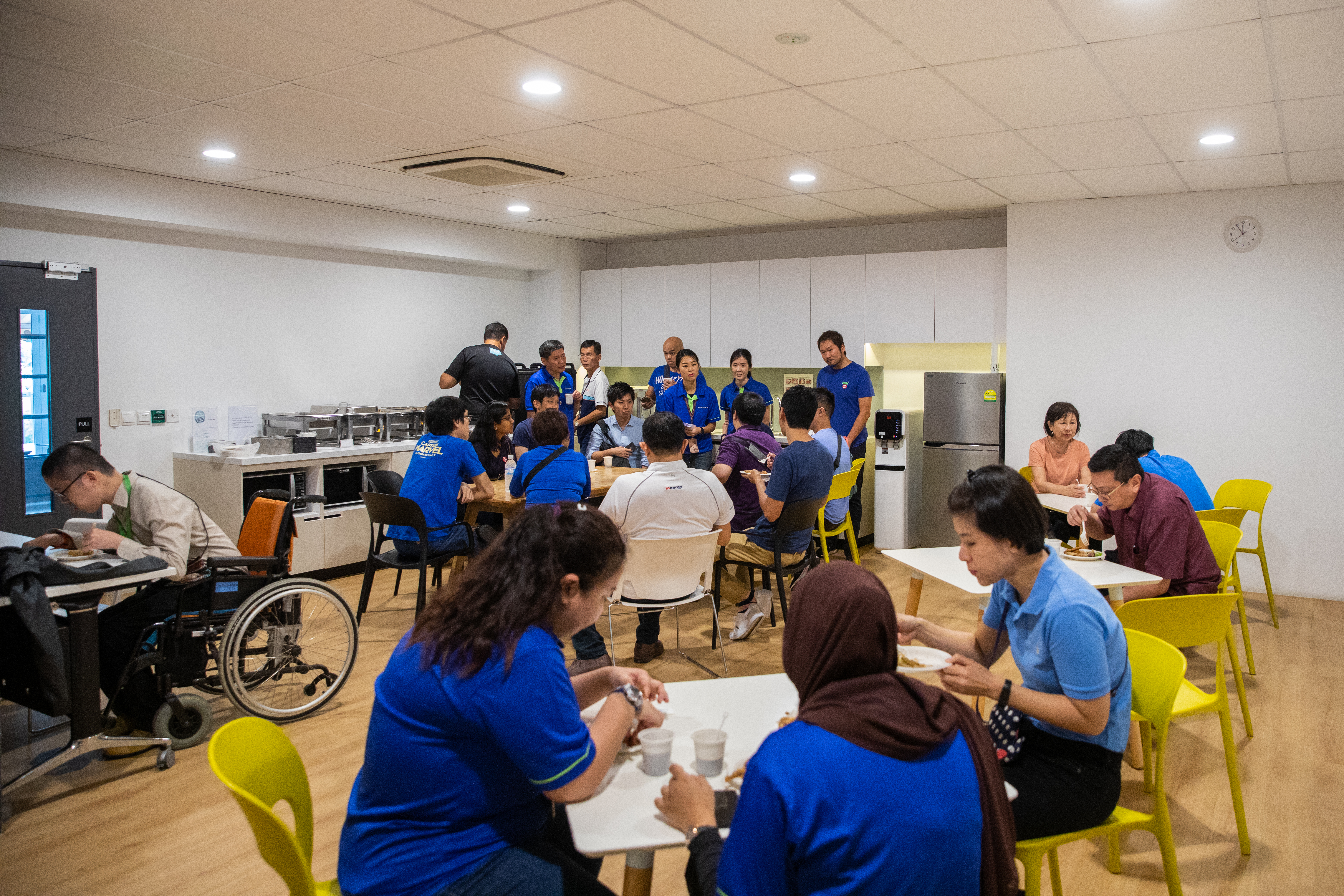 03-CVWorkshop & Trainer Booths-14 Participants and SG Enable staff sit in separate groups in a classroom setting.