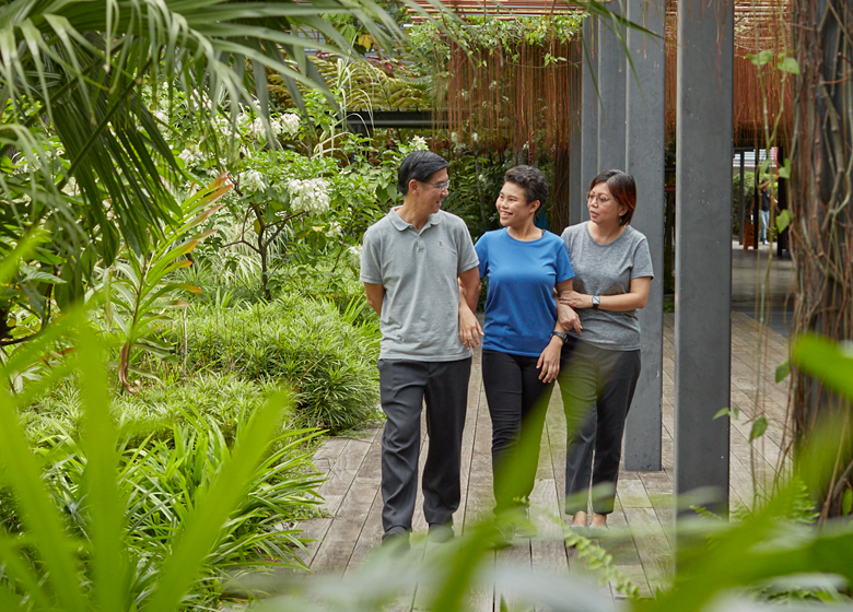 A family of three taking a walk through Enabling Village.