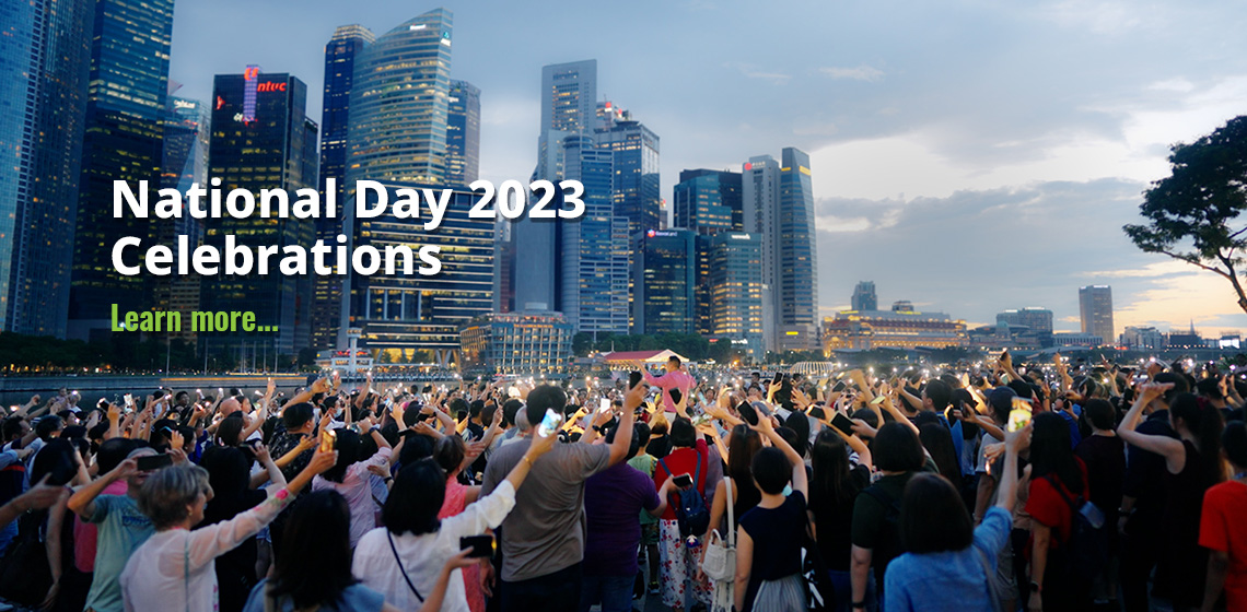 Photo of a crowd gathered at MBS event square, with everyone holding up their phones. Text reads, National Day 2023 Celebrations, Learn more...