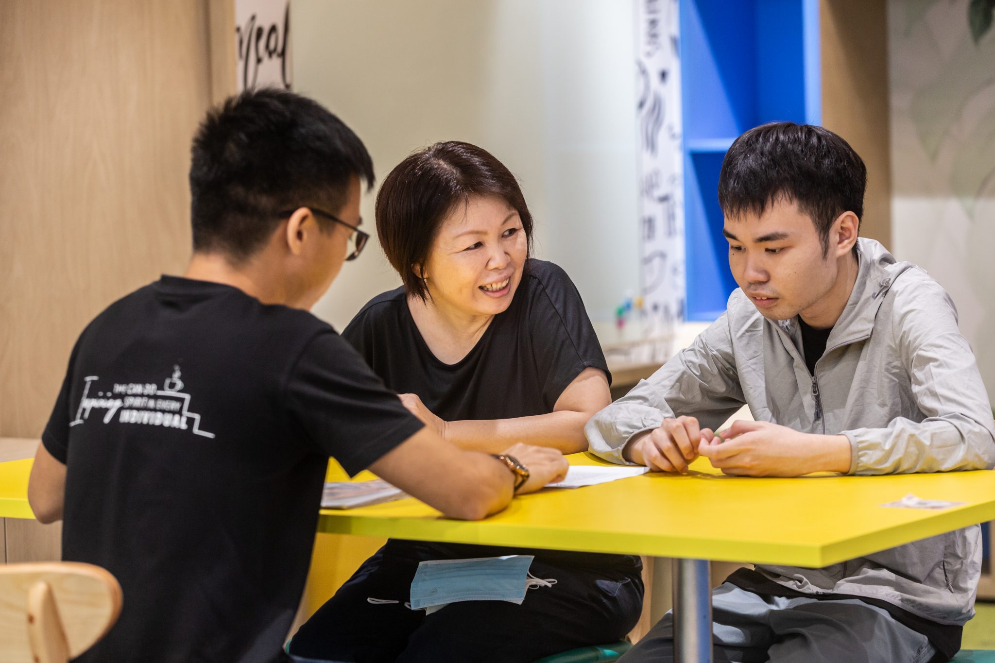 A woman and two young man in a discussion.