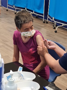 Image of a person with disability receiving the COVID-19 Vaccination