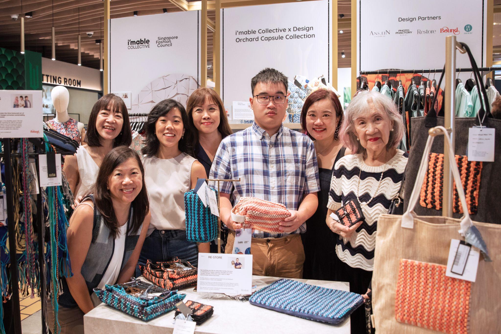 a group of individuals taking a photo together with a few handmade products in front of them