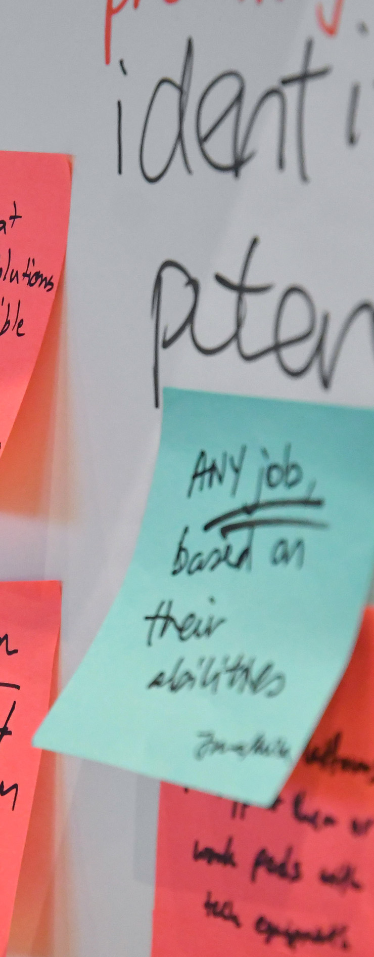 A few pink and blue post-its on a white board portraying a brainstorming/discussion session.