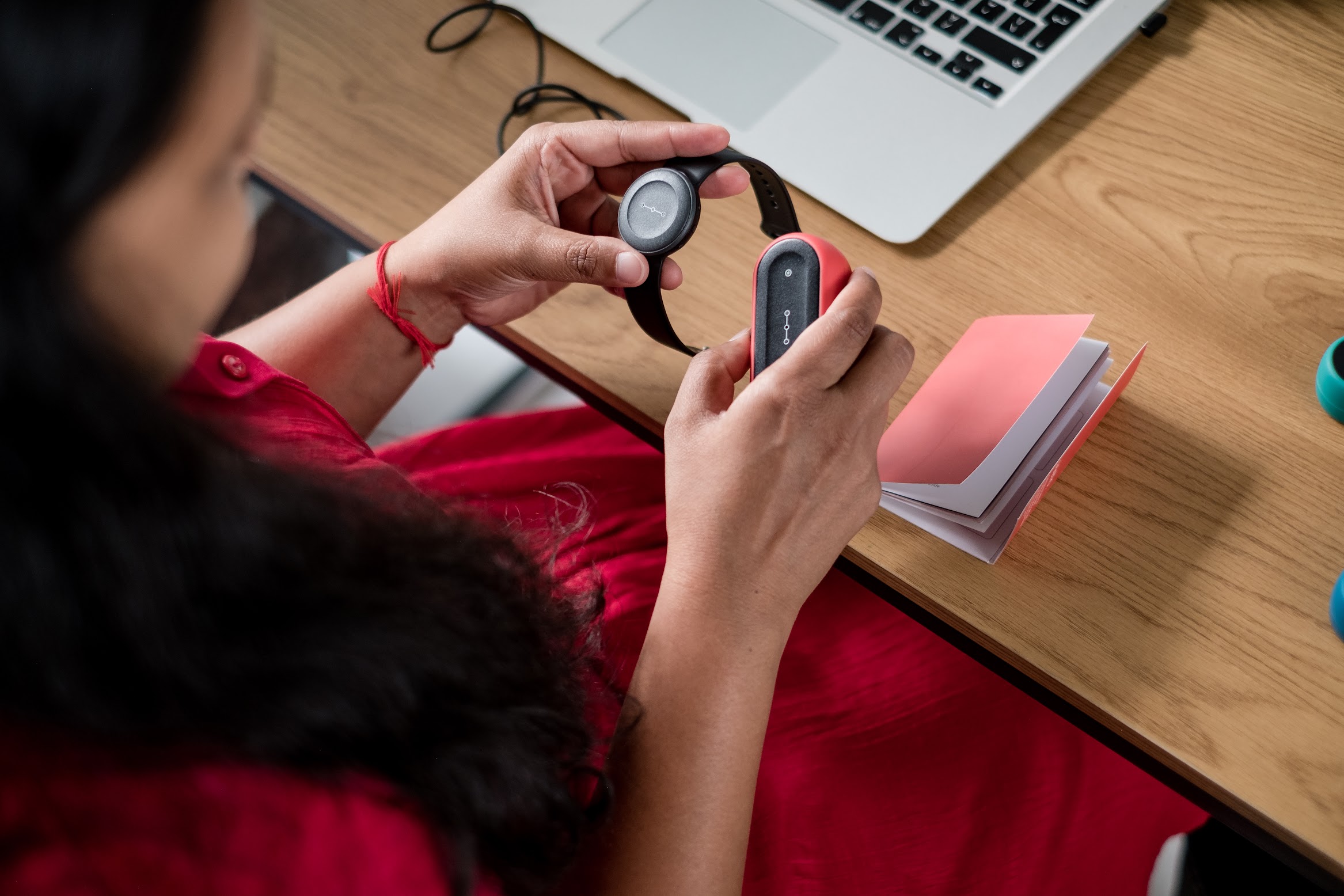 A woman setting up her watch-like device.